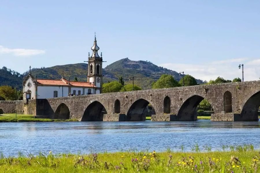 Die mittelalterliche Steinbrücke über den Lima in Ponte de Lima mit der weißen Kirche Santo António da Torre Velha