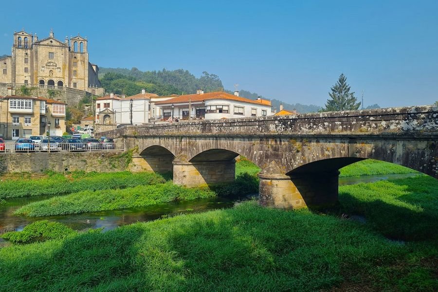 Die Santiago-Steinbrücke über den Sar in Padrón, dahinter auf dem Hügel das Carmen-Kloster