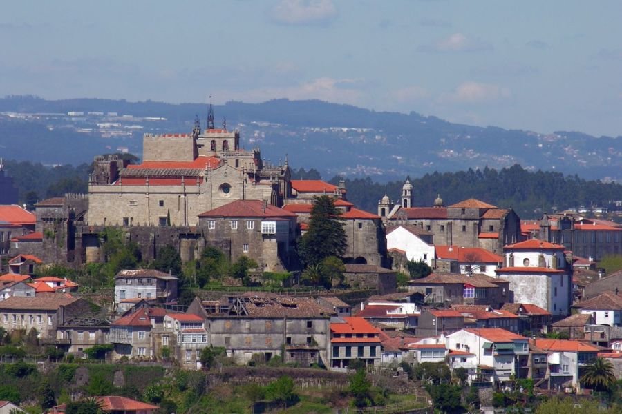 Die Altstadt von Tui auf ihrem Hügel, gekrönt von der Kathedrale, mit roten Ziegeldächern und den galicischen Hügeln im Hintergrund