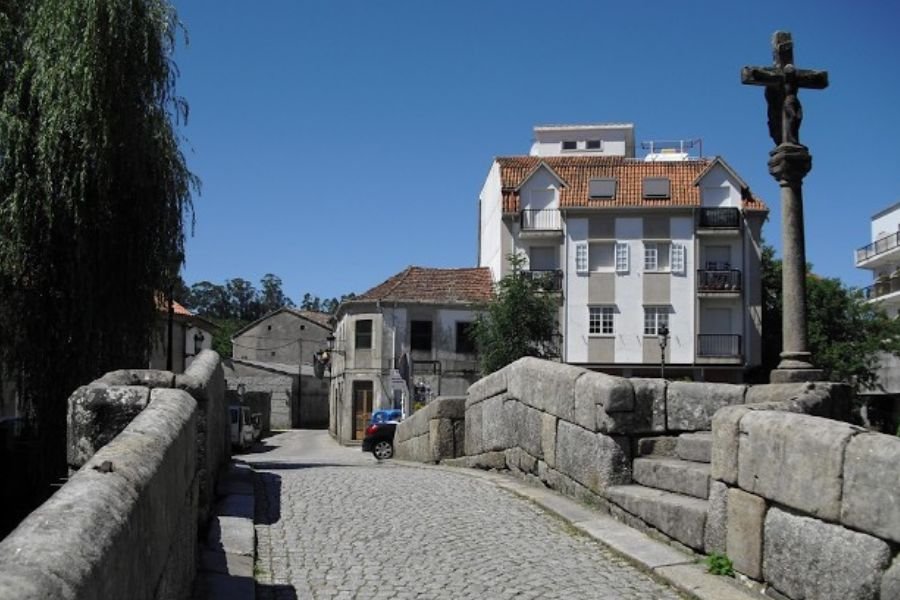 El antiguo puente de piedra de Caldas de Reis, con un cruceiro de piedra al lado