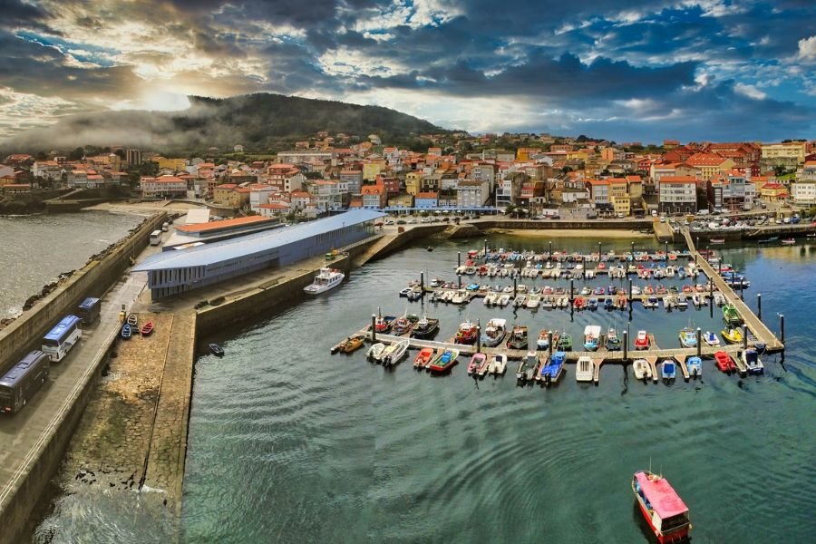Aerial view of the fishing port and town of Finisterre, with boats moored in the marina
