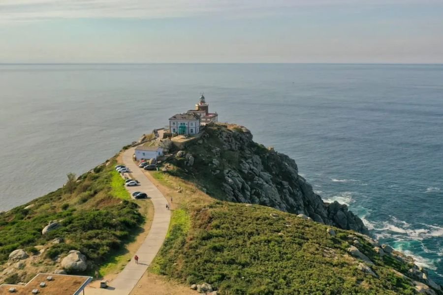 Aerial view of the Cape Finisterre lighthouse on a rocky headland above the Atlantic Ocean